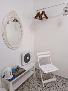 een witte kamer met een stoel en een spiegel bij Pensión Playa in Los Cristianos