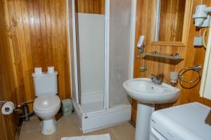 a bathroom with a toilet and a shower and a sink at Tree Houses Hotel in Fethiye