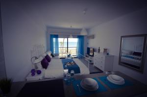 Schlafzimmer mit einem Bett und Meerblick in der Unterkunft Krasas Beach Apartment Rentals in Larnaka