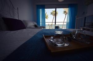 a hotel room with a tray of food on a bed at Krasas Beach Apartment Rentals in Larnaka