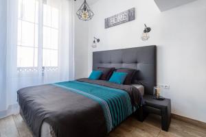 a bedroom with a large bed with blue pillows at JEAN MÉDECIN - Modern Flat - Heart of center in Nice