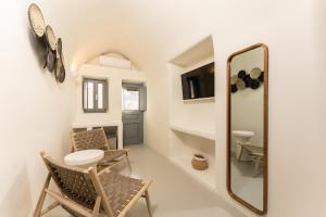 a room with a mirror and chairs and a table at Cilon Suites Santorini in Imerovigli