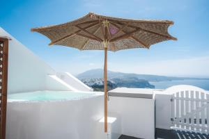 an umbrella on a balcony with a swimming pool at Cilon Suites Santorini in Imerovigli
