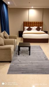 吉達的住宿－Yan Apartments，一间卧室配有一张床、一张沙发和一张桌子