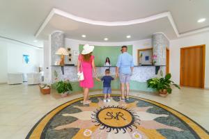 a family standing in the lobby of a hotel at Villaggio Spiagge Rosse in Capo Rizzuto +88 photos