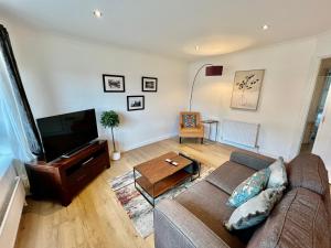 a living room with a couch and a flat screen tv at Mango Tree Apartment in Cambridge