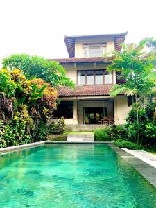 a house with a swimming pool in front of a house at Pondok Naya - CHSE Certified in Ubud
