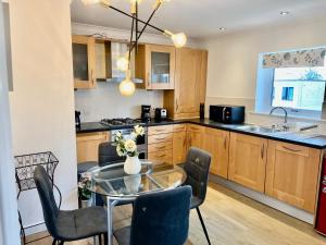 a kitchen with a table and chairs and a kitchen with a sink at Mango Tree Apartment in Cambridge