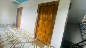 a room with a wooden door and a tiled floor at Dusilu Homestay in Bhadrak