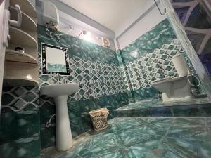 a green and white bathroom with a sink and a mirror at Dusilu Homestay in Bhadrak +13 photos