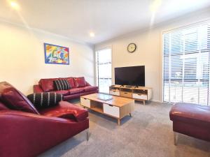 uma sala de estar com um sofá e uma televisão em Nelson City Town House 10 minute walk to town em Nelson
