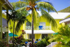 a yellow building with palm trees in front of it at Bay Gardens Hotel in Gros Islet