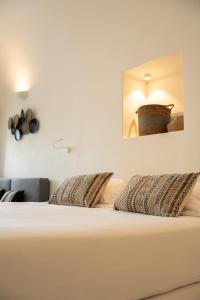 a white bed with two pillows in a bedroom at Cilon Suites Santorini in Imerovigli