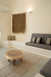 a living room with a coffee table in front of a couch at Cilon Suites Santorini in Imerovigli