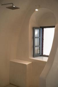 a room with a window and a stair case at Cilon Suites Santorini in Imerovigli