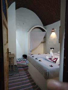 a bedroom with a white bed with a cat on it at Nubian King in Aswan