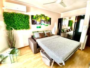 een slaapkamer met een bed en een bank bij Le Nouveau Port By SCLS Locations in Cannes