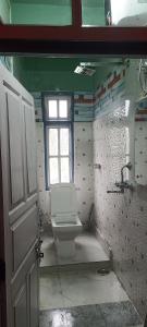 a bathroom with a toilet and a window at Drishtee Homestay in Rongli