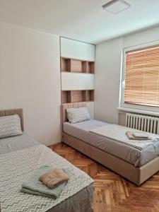 a bedroom with two beds and a window at D&D Centar Apartment in Skopje