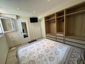 1 dormitorio con 1 cama grande y espejo en Appartement Les Moulins, en Saint-Tropez