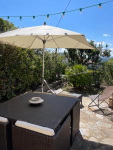 un tavolo con ombrellone su un patio di Appartement Les Moulins a Saint-Tropez