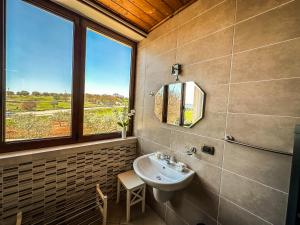 baño con lavabo y ventana en B&B Il Leccio, en Alberobello