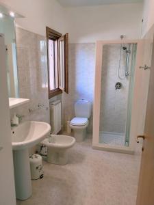 a bathroom with a toilet and a sink and a shower at Doris' home in Pisogne