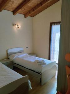 a bedroom with two beds and a window at Doris' home in Pisogne