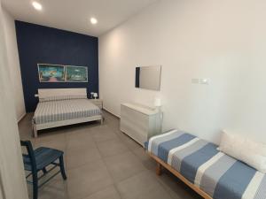 um quarto com duas camas e uma cadeira. em Casa Ribes em Santo Stefano al Mare