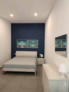 a bedroom with a bed and three paintings on the wall at Casa Ribes in Santo Stefano al Mare