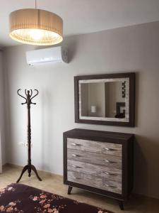 een kamer met een dressoir met een spiegel en een lamp bij Apartamento nuevo en pleno centro. in Carboneras