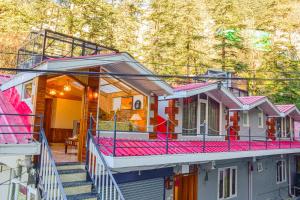 a row of houses with pink railing and stairs at Singhs BnB by Lazy Getaways in Shimla
