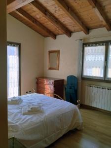 a bedroom with a bed and a dresser and windows at Doris' home in Pisogne