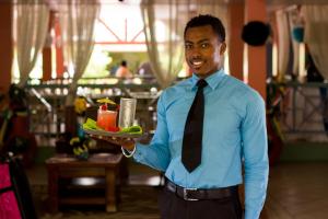 a man in a tie holding a plate of food at Bay Gardens Hotel in Gros Islet