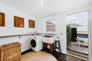 a white room with a washing machine and a window at 'Mortimer Gardens' Country Charm in the Heart of Mudgee in Mudgee