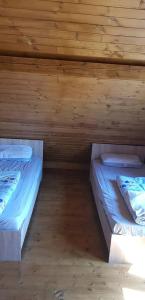 にあるOur little forest houseのベッド2台 木製の壁の部屋