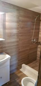 にあるOur little forest houseのバスルーム(木製の壁、トイレ、洗面台付)