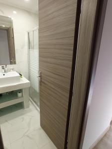 baño con puerta de madera y lavamanos en Horizon en Pefkohori