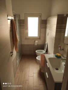 baño con lavabo y aseo y ventana en Casa vacanze Marinella, en Cetraro