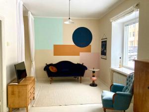 a living room with a couch and a tv at Spacious (44 sqm) bohemian studio in trendy Kallio in Helsinki