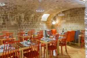 a restaurant with wooden tables and chairs and a brick wall at Hotel Lorette - Astotel in Paris