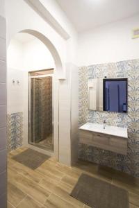 a bathroom with a sink and a mirror at La Paranza Apartments Lampedusa in Lampedusa