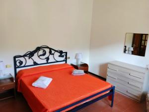 a bedroom with a red bed with a dresser and a mirror at Tra Mare e Monti in Borzonasca
