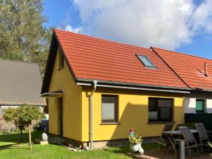 a yellow and orange house with a red roof at Bei Ziegers Ferienhaus in Wustrow