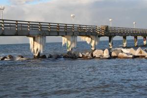 a bridge over the water with ice hanging from it at Bei Ziegers Ferienhaus in Wustrow