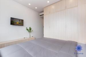 una camera con un grande letto e una parete bianca di Apartments near Tân Sân Nhất Airpot ad Ho Chi Minh