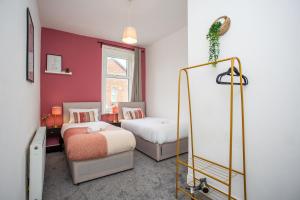 a bedroom with two beds and a mirror at Heaton Retreat Modern & Spacious staycation in Heaton