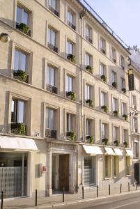 un grand bâtiment avec des plantes sur les fenêtres dans l'établissement Hotel Lorette - Astotel, à Paris