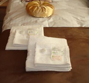 twee foto's van handdoeken op een bed met een kussen bij Apartament Central in Piatra Neamţ