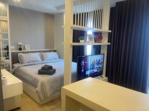 a bedroom with a bed with a television in it at The Patio bangsaen miracle Seaview in Ban Bang Saen (1) +17 photos